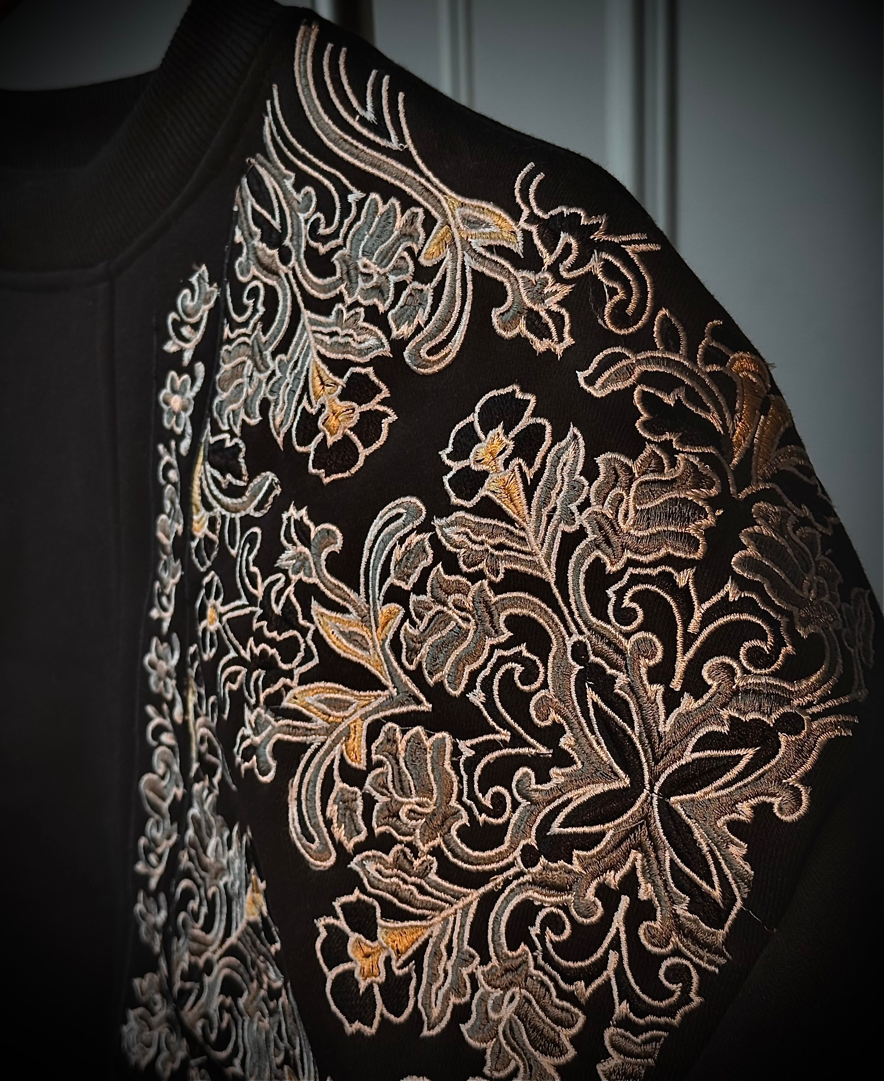Close-up of a black Sweatshirt with intricate gold floral embroidery by vivant wear